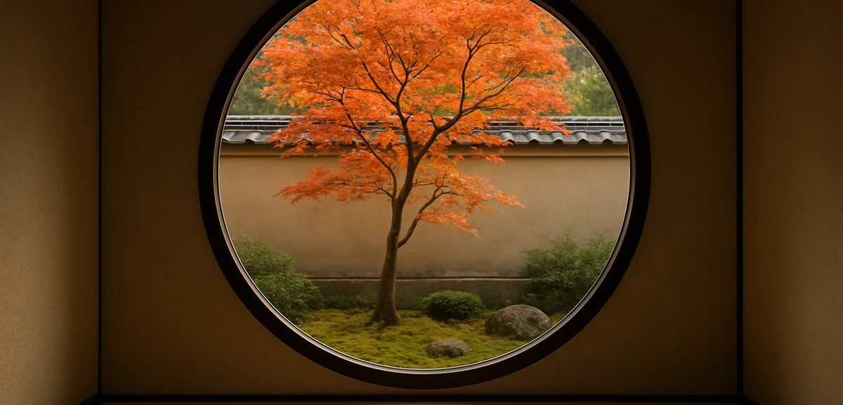 View through a round window in a Japanese room toward a single maple tree in a small courtyard garde